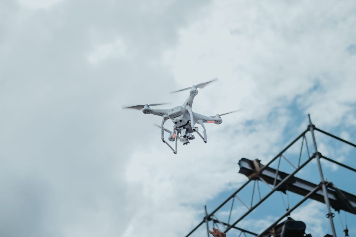 Drone hovering in flight against a cloudy sky background.