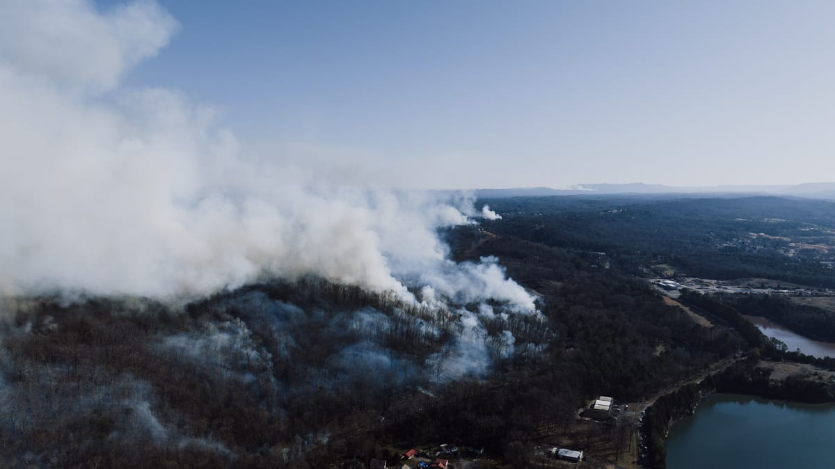 Aerial drone photo of wildfire smoke billowing above a forested ridge near Rossville, Georgia.
