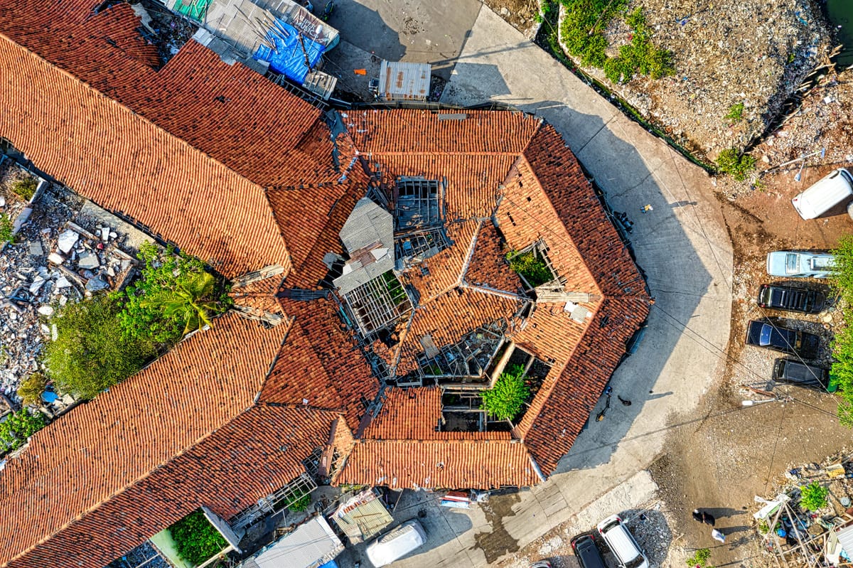 Aerial view of a large urban rooftop showing weathered building exterior.