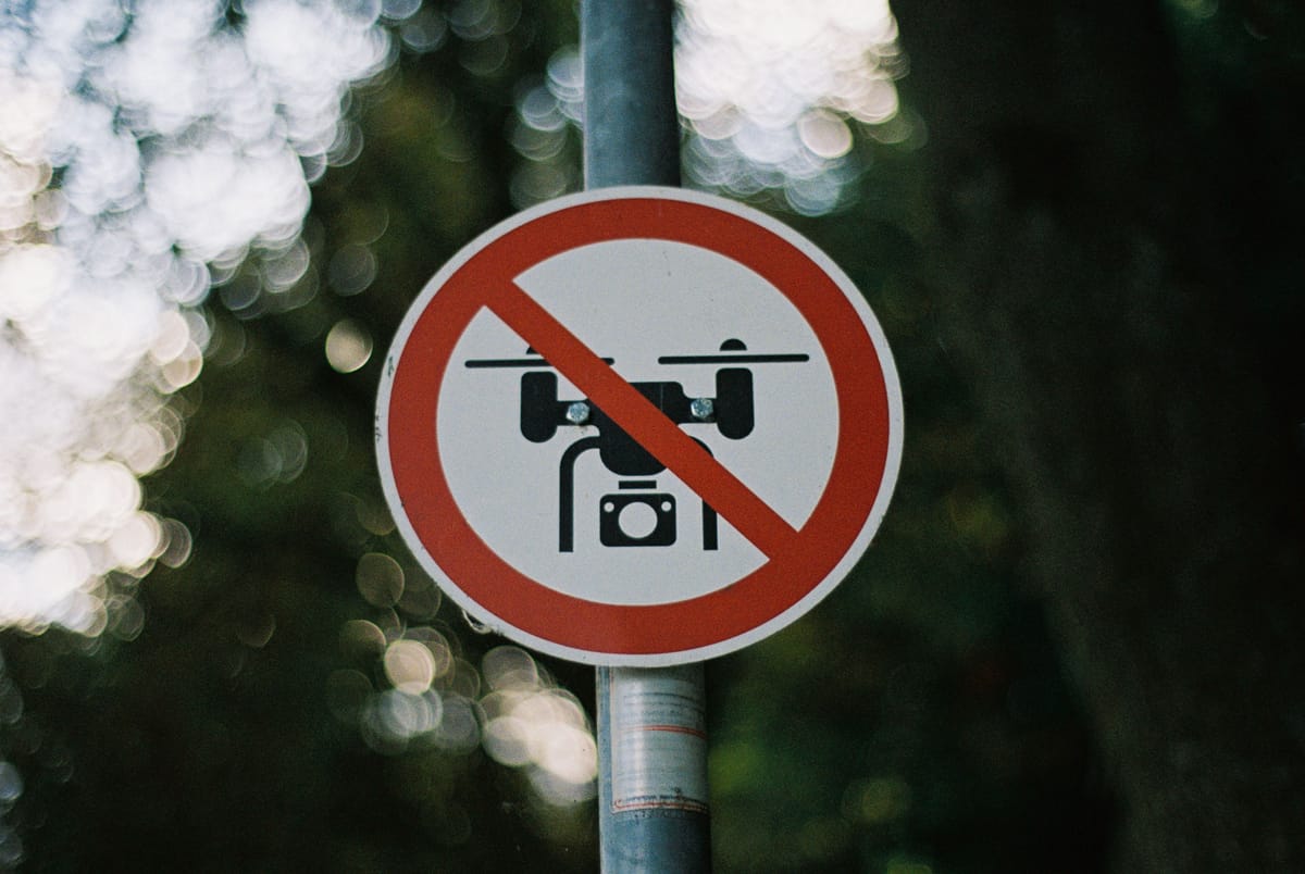 No drone zone sign mounted outdoors in a natural setting.