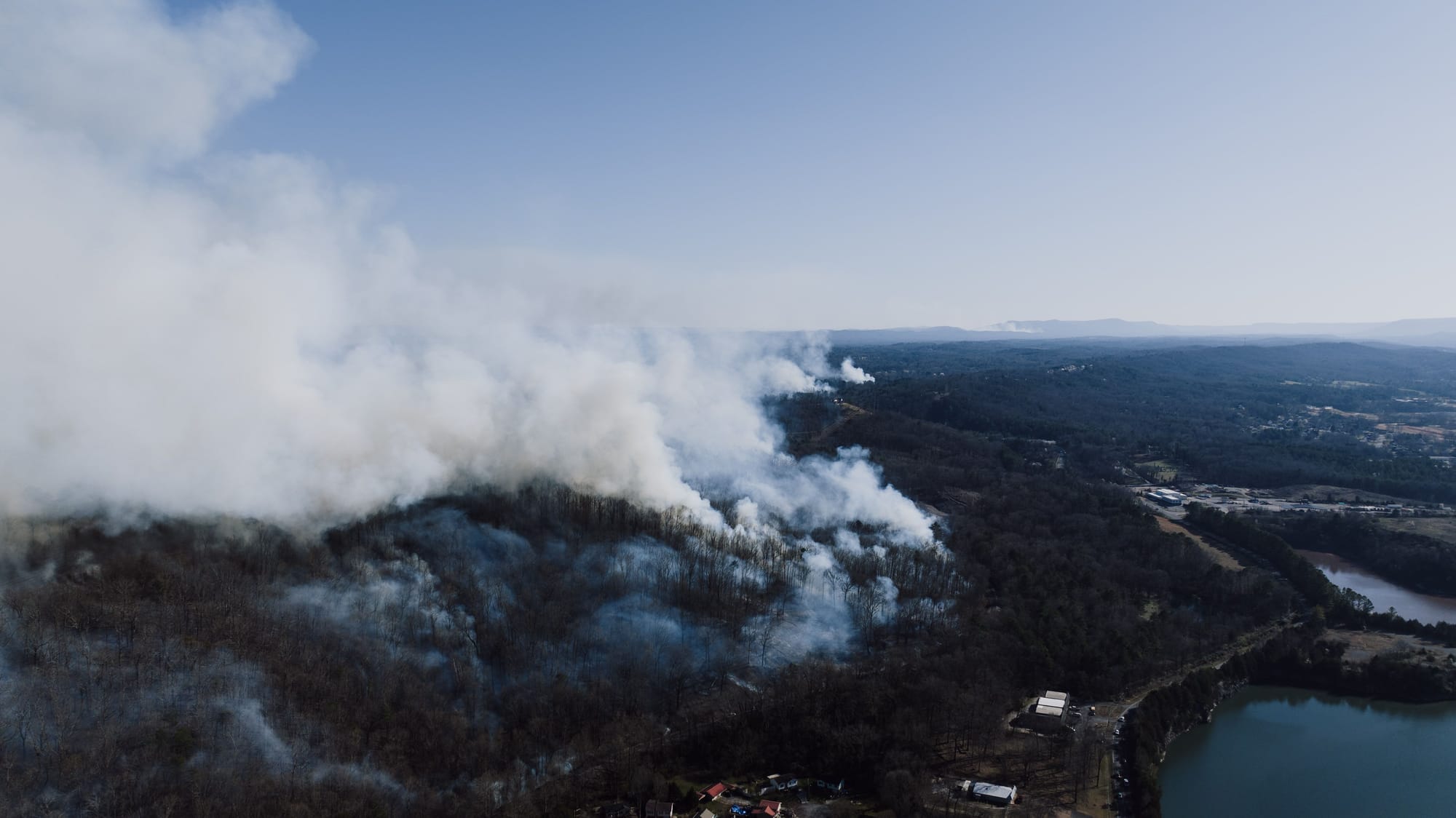 Aerial drone photo of wildfire smoke billowing above a forested ridge near Rossville, Georgia.