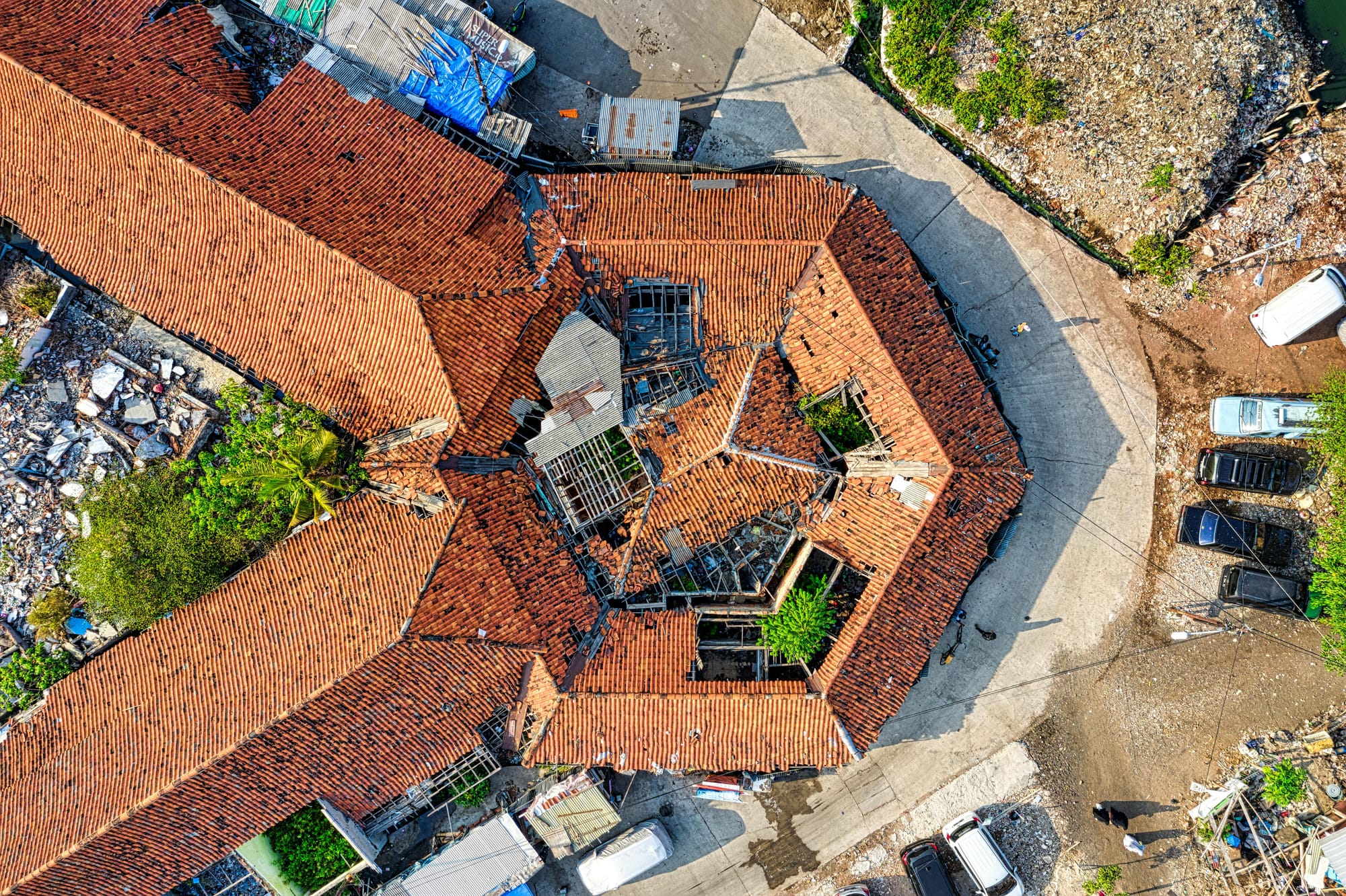 Aerial view of a large urban rooftop showing weathered building exterior.
