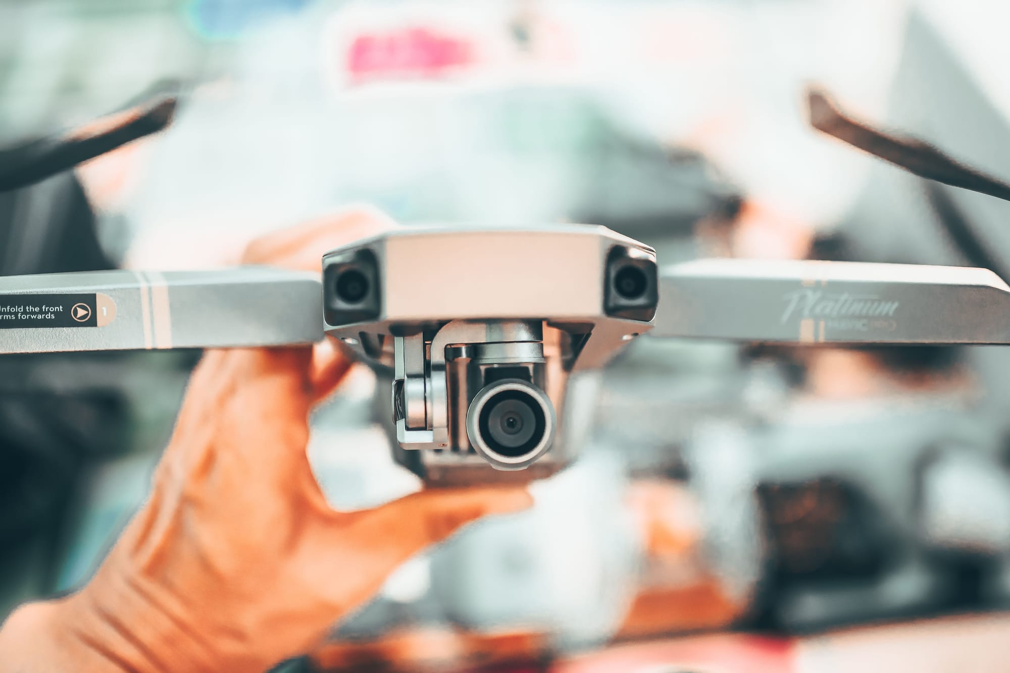 Drone operator in an urban setting, holding a small professional drone.