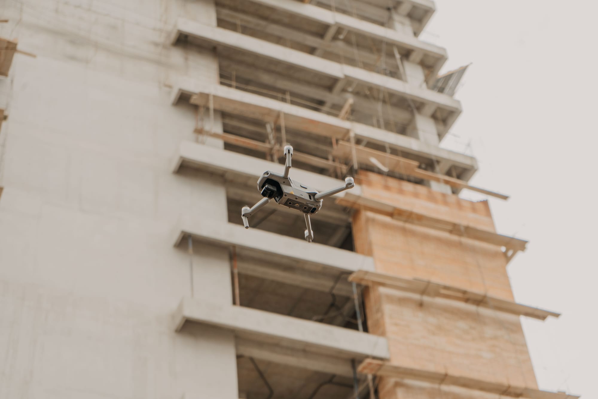 Aerial view of a drone over an active multi-story construction site.
