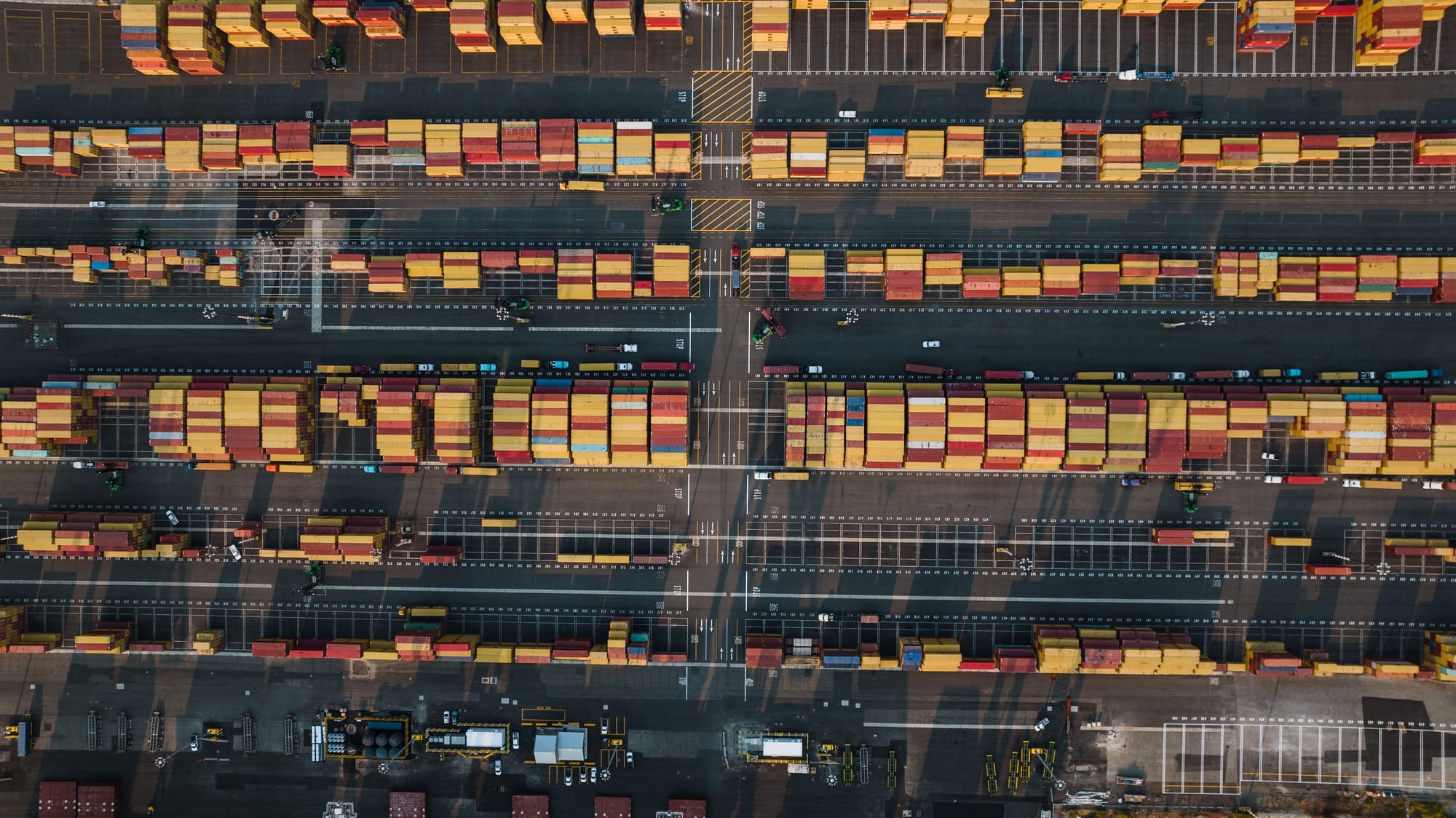 Aerial view of shipping containers at a busy port terminal.