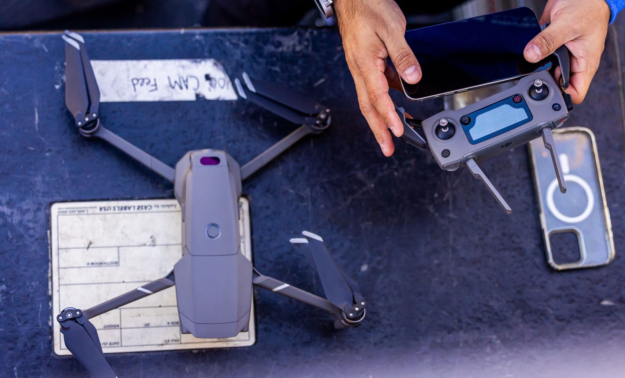 Drone and controller arranged on an outdoor table before a flight.