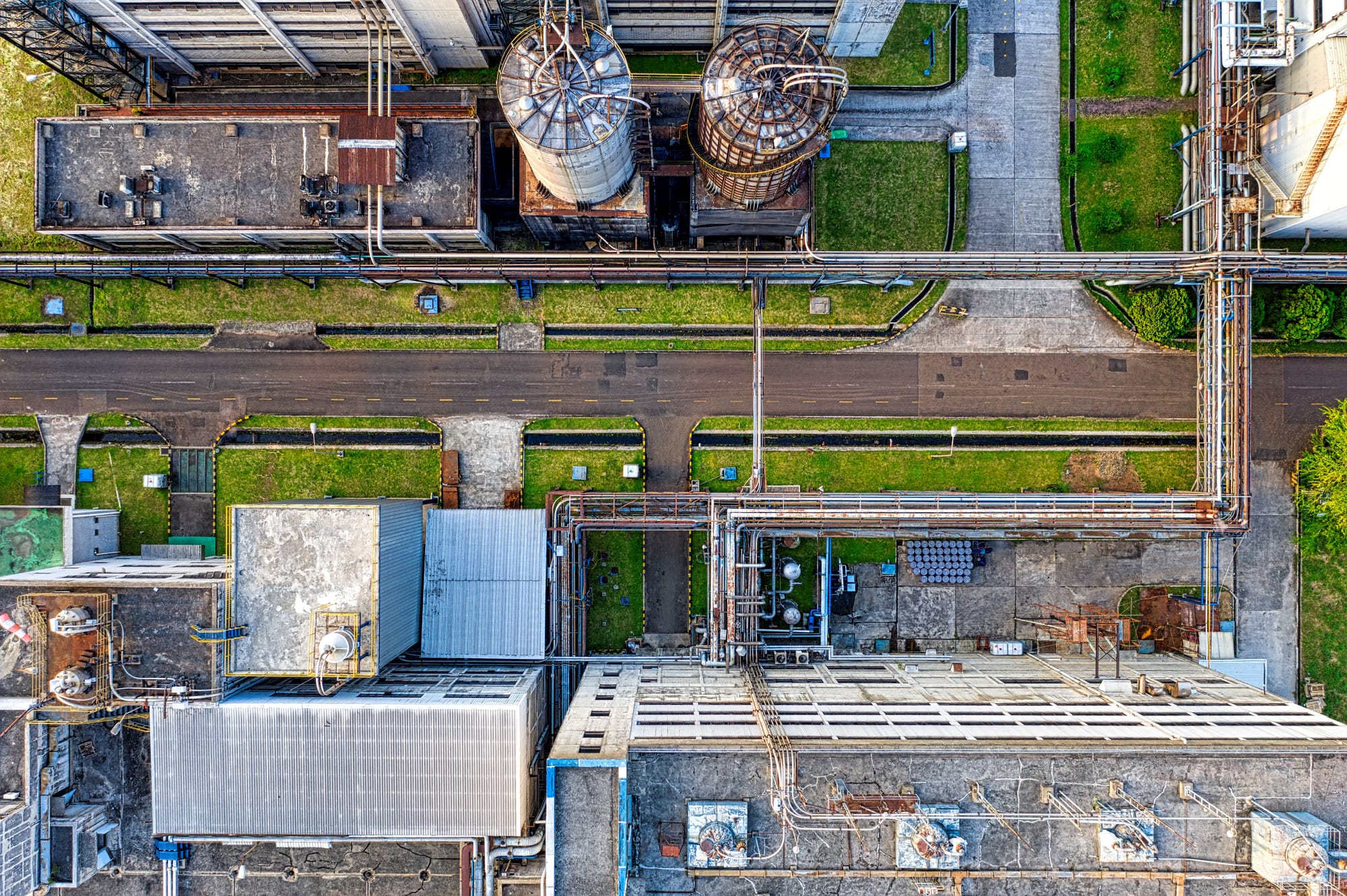 Aerial drone view of industrial pipes, tanks and facility infrastructure.