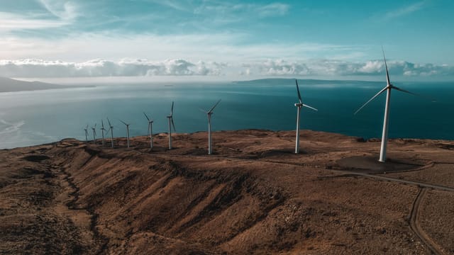 Aerial view of wind turbines near water.